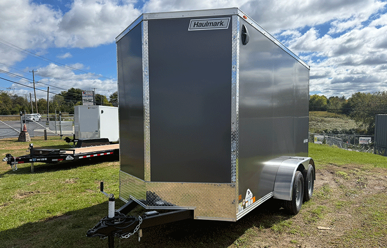 V-Nosed Enclosed Cargo Trailer in grey on grass lot